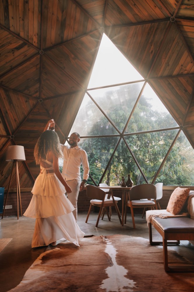 Casal dançando dentro de um domo de madeira
